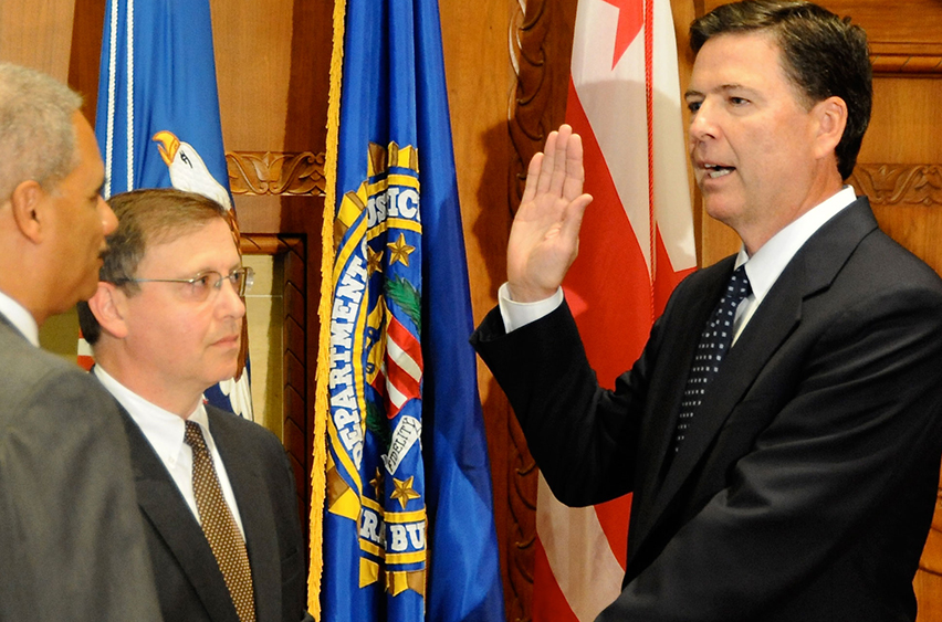 James B. Comey is sworn in as FBI Director by Attorney General Eric Holder on September 4, 2013; Chuck Rosenberg, senior counselor to Director Comey, holds the Bible.